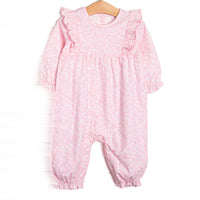 This romper features a pink floral print, ruffle trim around the neck, and snaps on the stride.