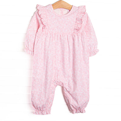 This romper features a pink floral print, ruffle trim around the neck, and snaps on the stride.