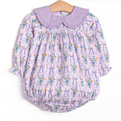  This bubble features a purple floral, a purple ruffle Peter Pan collar, and long sleeves. 