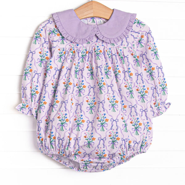  This bubble features a purple floral, a purple ruffle Peter Pan collar, and long sleeves. 