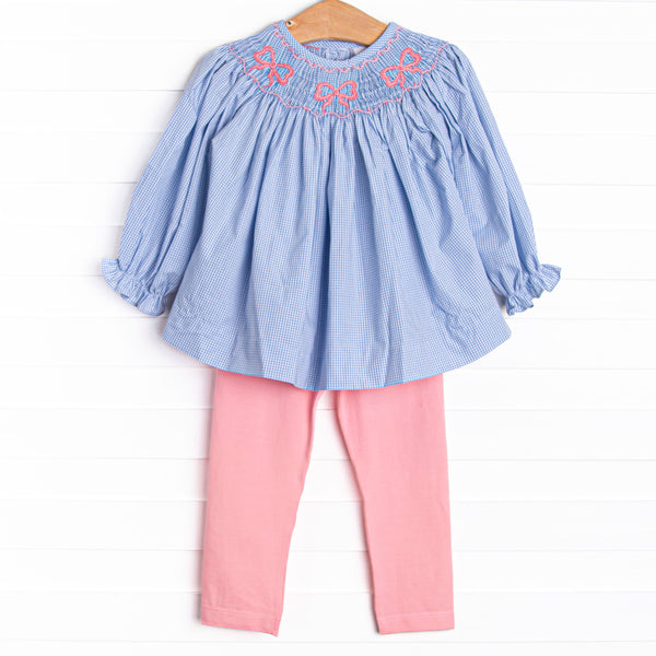 This set features a blue gingham print, bow smockings, and&nbsp; coordinating pink leggings to match.
