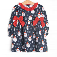  This dress features a Santa print, a ruffle collar, and red side ties. 