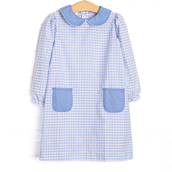 This dress features a blue plaid print, a blue peter pan collar, and blue front pockets.