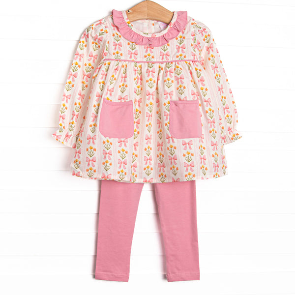 This set features pink floral and bow print, a pink ruffle collar, and front ruffle pockets. Coordinating pink leggings to match.