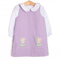 This set features a purple pique dress, a white top, a Peter Pan collar, and floral applique.