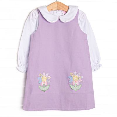 This set features a purple pique dress, a white top, a Peter Pan collar, and floral applique.