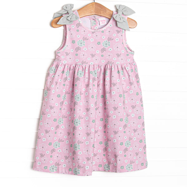 This dress features a pink floral, green gingham bow details, and button closure on the back