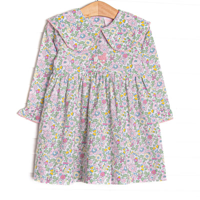 This dress features a pink flower print, a picot trimmed bib collar, and a French knot poodle embroidery.