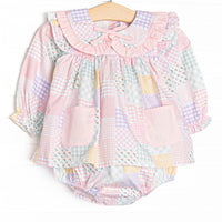  This skirted bubble features a pink quilt pattern, a ruffle Peter Pan collar, a pre tied bow, and pink front pockets. 