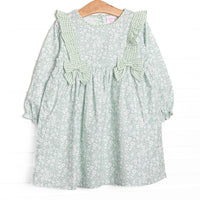  This dress features a green floral print, green ruffle trim, and green bows. 