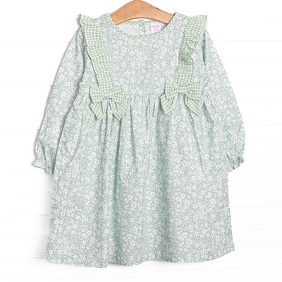  This dress features a green floral print, green ruffle trim, and green bows. 