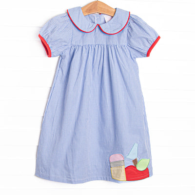  This dress features a blue gingham pattern, apple and pencil applique, a peter pan collar, and red piping and trim. 