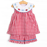 This set features a red check print, a bib collar and a dainty school embroidery. Matching ruffle shorts with blue ric rac trim.
