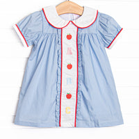 This dress features blue gingham material, puff sleeves, and abc and apple embroidery. 
