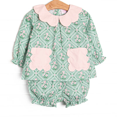 This set features a tile and floral print, a pink scalloped collar, and pink scalloped front pockets. Coordinating bloomer shorts to match.