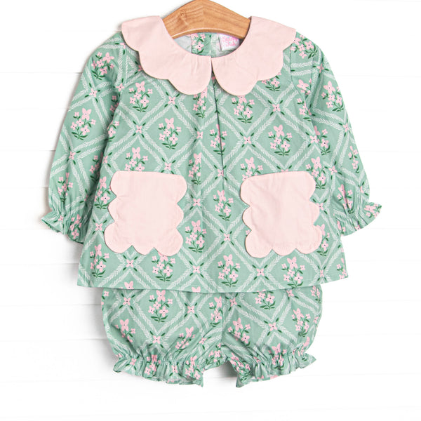 This set features a tile and floral print, a pink scalloped collar, and pink scalloped front pockets. Coordinating bloomer shorts to match.