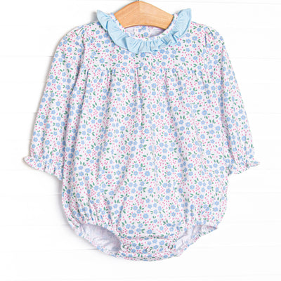 This bubble features a blue floral print, blue ruffle collar, and snaps on the stride to make changing a breeze. 