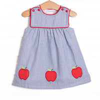 This dress features navy seersucker print, apple trio applique, and red piping.