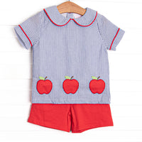 This set features navy seersucker top with a peter pan collar, and&nbsp; apple trio applique. Coordinating red shorts to match.