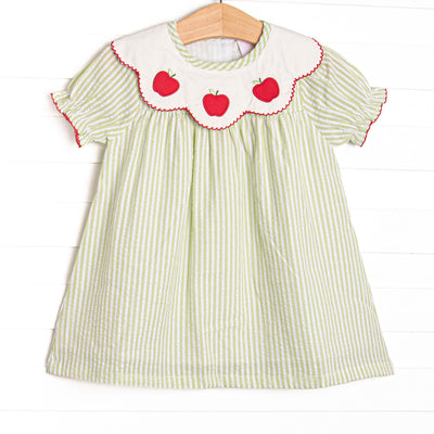 This dress features green seersucker material, apple trio applique on the collar, and red trim.