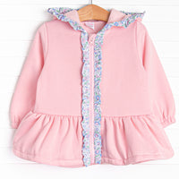 This jacket features the softest pink fleece material, a cozy hoodie, and floral ruffle trim.