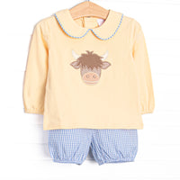 This set features a yellow top, Highland cow applique, and a yellow Peter Pan collar. Coordinating blue gingham bloomer shorts to match.