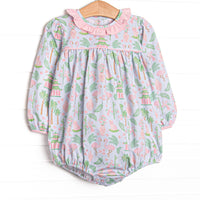  This bubble features a mahjong inspired print, pink ruffle collar, and snaps on the stride. 