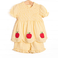 This set features a yellow gingham print, puff sleeves, and apple trio applique.