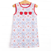 This dress features a white blue bow and apple pattern, red trim and a trio of apple appliques.