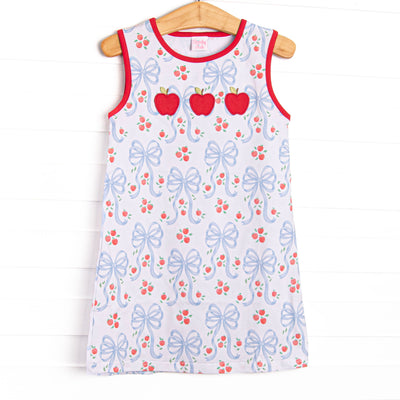 This dress features a white blue bow and apple pattern, red trim and a trio of apple appliques.