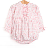 This bubble features a pink dainty unicorn print, a trio of pink satin bows, and ruffle trim.