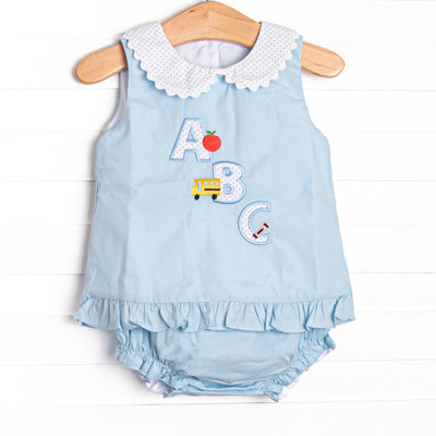 A sweet applique featured in blue bitty dot that is perfect for back to school! This woven diaper set will be a favorite for your little girl. Peter pan collar, button down back, and pull on diaper cover
