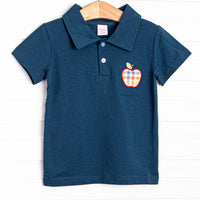 This top features a navy blue knit, polo collar, and a plaid apple applique.
