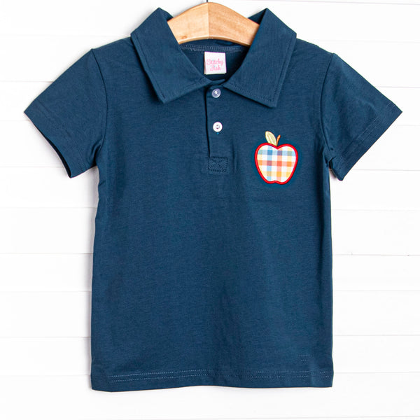 This top features a navy blue knit, polo collar, and a plaid apple applique.