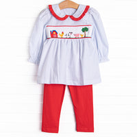 This set features a blue windowpane print, red ruffle trim, and a barn smocking. Coordinating red leggings to match.