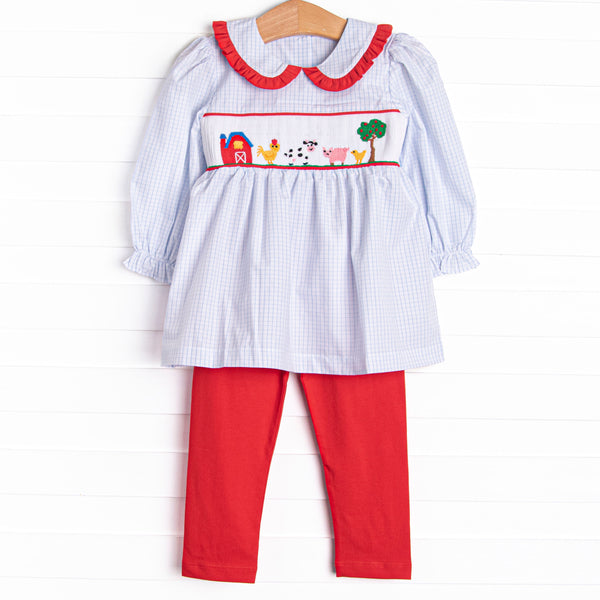 This set features a blue windowpane print, red ruffle trim, and a barn smocking. Coordinating red leggings to match.