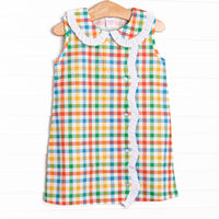 This dress features a plaid print, a peter pan collar, and white ruffle trim.