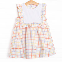  This dress features a plaid print, a bib collar, and ruffle trim. 