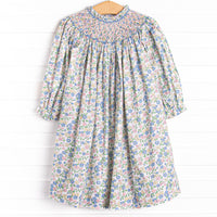  This dress features a pink floral print, button closure on the back, and the sweetest smocking. 