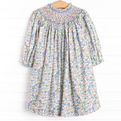  This dress features a pink floral print, button closure on the back, and the sweetest smocking. 