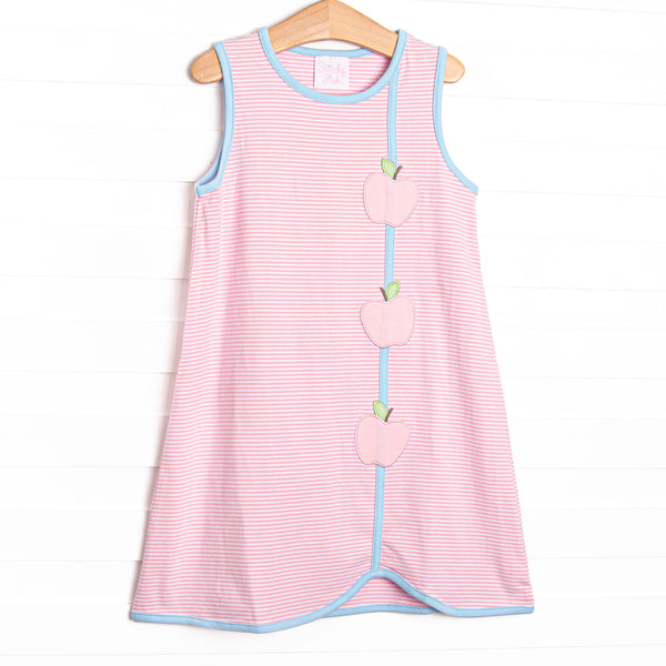 This dress features a pink striped print, blue trim, and apple appliques.