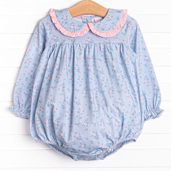  This bubble features a blue floral print, a peter pan collar with pink ruffle trim, and snaps on the stride. 