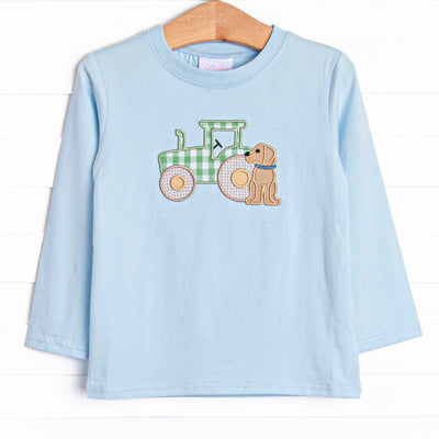  This shirt features a blue knit material, long sleeves, and a tractor and puppy applique. 