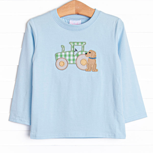  This shirt features a blue knit material, long sleeves, and a tractor and puppy applique. 