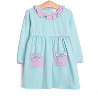 This dress features mint green stripes, front pockets, and ruffle trim. 