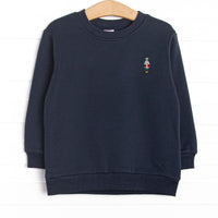  This sweatshirt features navy blue fleece fabric, a sugar plum soldier embroidery, and long sleeves. 