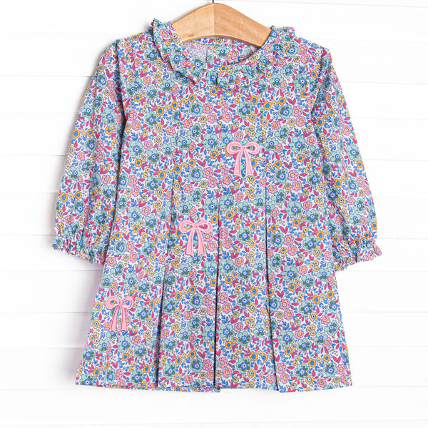 This dress features a purple floral print, a ruffle collar ,and a trio of bows appliques.