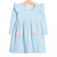 The dress features front ruffle pockets, peach striped trim, and the softest blue knit material. 