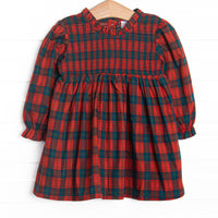  This dress features red plaid fabric, chest smocking, and long sleeves. 