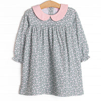  This dress features a green floral print, pink peter pan collar, and button closure on the back. 